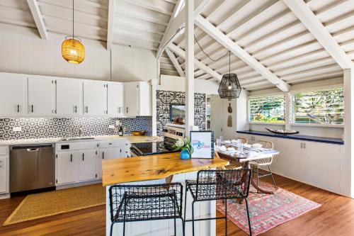 a kitchen with white cabinets and a wooden table at International Colony 17 in Lahaina