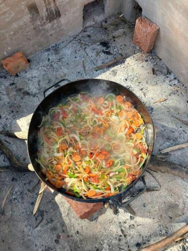 a pan full of vegetables cooking on a grill at Complejo de Cabañas Eco-sustentables - La escondida - in San Salvador de Jujuy