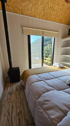 a bedroom with two beds and a large window at Complejo de Cabañas Eco-sustentables - La escondida - in San Salvador de Jujuy