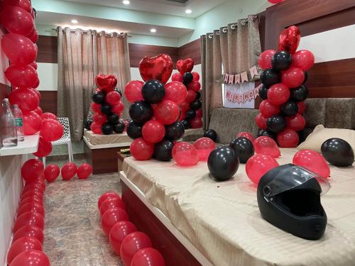 een kamer met een bed met rode en zwarte ballonnen bij OYO Hotel Anandam Residency in Dhanbad