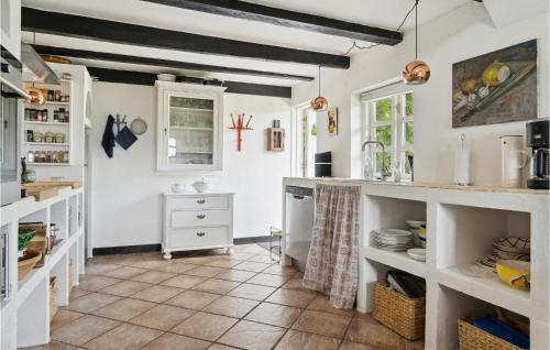 cocina con armarios blancos y suelo de baldosa en Awesome Home In Stokkemarke With Kitchen en Stokkemarke