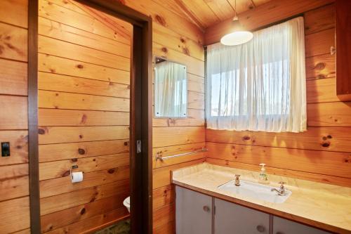 a bathroom with a sink and a window at The White Haus - Waihi Beach Upstairs Holiday Unit in Waihi Beach