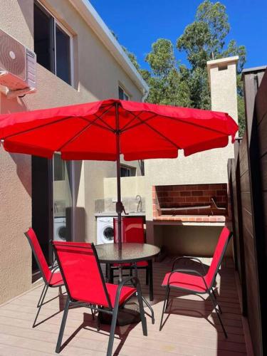 a table and chairs with a red umbrella on a patio at Vista24uy Ref1003 in Bella Vista