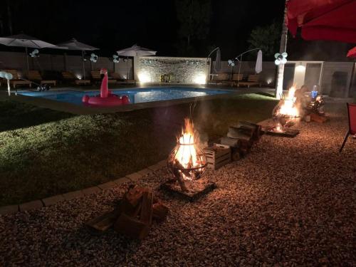 a pool with a fire pit in the yard at night at Casa para 4 personas en vista24uy, Bella Vista, Maldonado in Bella Vista