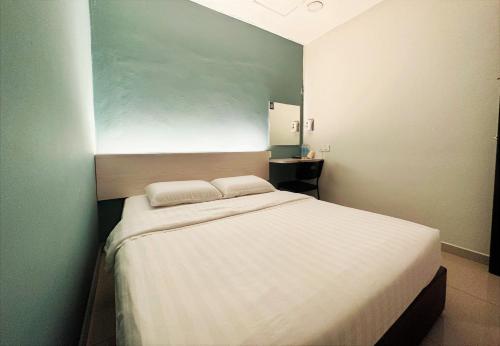 een slaapkamer met een groot bed met 2 kussens erop bij De UPTOWN Hotel @ Damansara Uptown in Petaling Jaya