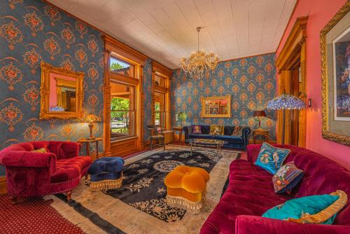 una sala de estar con sofás rojos y paredes azules. en Orman Mansion - Pueblo's Most Luxurious Stay! en Pueblo
