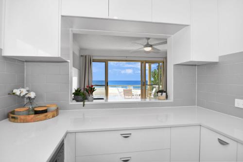 a white kitchen with a view of the ocean at Avilla Court Stunning Views in The Entrance