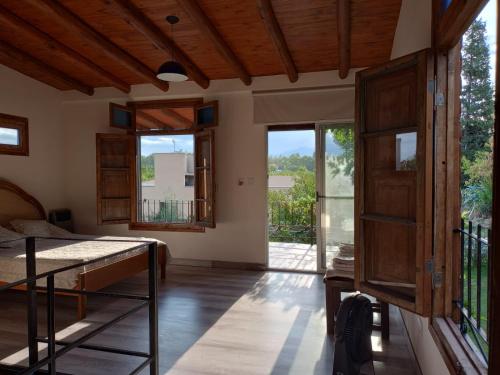 Cette chambre comprend un lit et quelques fenêtres. dans l'établissement Chacras casa Armonia, à Chacras de Coria