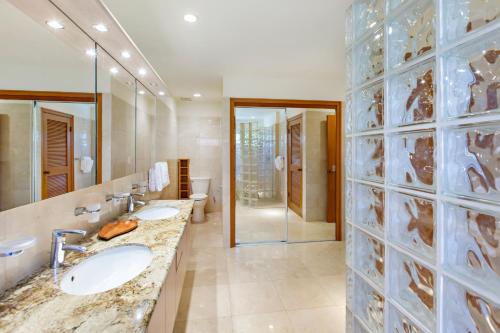 a bathroom with two sinks and a glass wall at Kapalua Ridge Villa 2622 in Kahana