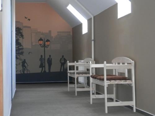 a room with two white chairs and a wall at Penzion Eden Turnov in Turnov
