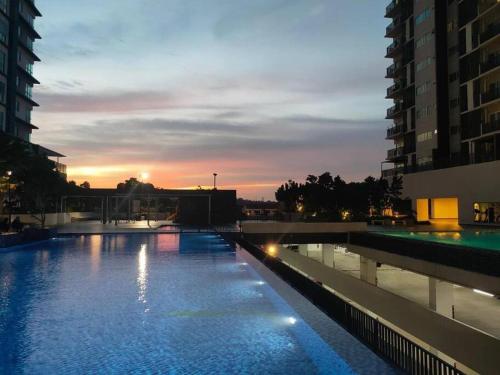una gran piscina con puesta de sol en el fondo en Cozy Studio Galleria Equine Park ,KLIA, MRT, AEON, FOOD STREET, en Seri Kembangan