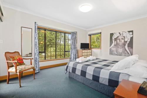 1 dormitorio con 1 cama, 1 silla y 1 ventana en Mountain Bike Vacation, en Rotorua
