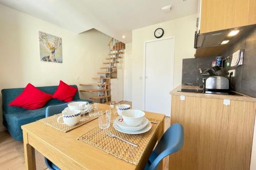 a kitchen with a table with bowls and plates on it at M8 Le vieux MassyRER600mOrly20 minNetflixNeuf in Massy