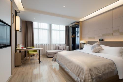 a hotel room with a large bed and a desk at Morning Hotel, Changsha Langli in Changsha