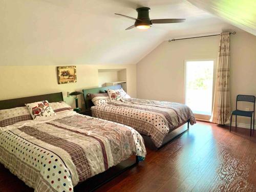 a bedroom with two beds and a ceiling fan at New & Cozy Niagara Getaway. 7 mins from the Falls in Niagara Falls