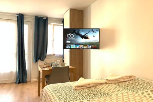 een hotelkamer met een bed en een tv aan de muur bij M2 Cosy studio RER BC500m Orly 20 min Netflix in Massy