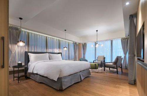 a bedroom with a large bed and a living room at Yamagata Kaku Hotel & Spa in Jiaoxi