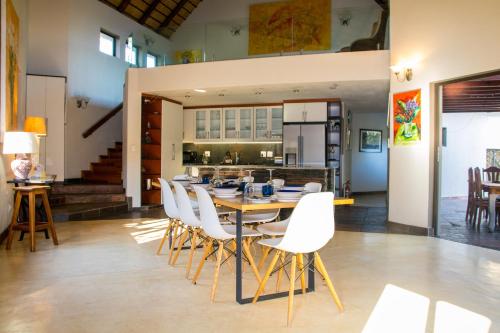 a dining room with a table and white chairs at Exbury Wild in Hoedspruit