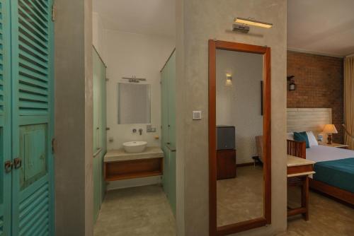 a room with a bathroom with a sink and a mirror at Beverly Suites Mount Lavinia in Mount Lavinia