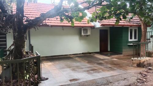 a house with a tree in front of it at Green Valley Holiday Home in Meppādi