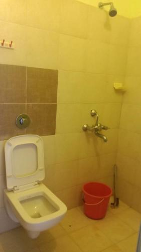 a bathroom with a toilet and a bucket at Green Valley Holiday Home in Meppādi