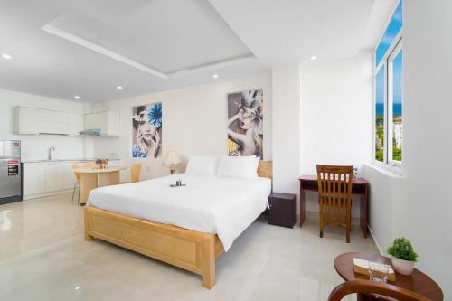 a bedroom with a large bed and a kitchen at Pearl Sea Hotel in Danang