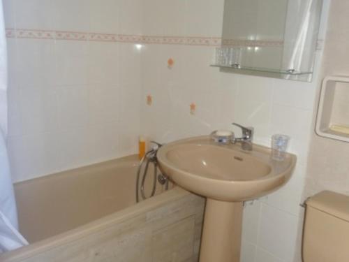 een badkamer met een wastafel en een bad bij Maison La Faute-sur-Mer, 2 pièces, 4 personnes - FR-1-476-203 in La Faute-sur-Mer