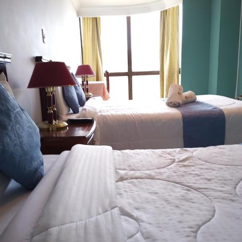 a hotel room with two beds and a window at HOTEL REALPICO VICTORIA in Duitama