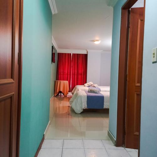 a bedroom with a bed and a red curtain at HOTEL REALPICO VICTORIA in Duitama