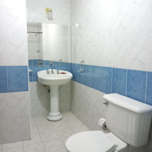 a bathroom with a toilet and a sink at HOTEL REALPICO VICTORIA in Duitama