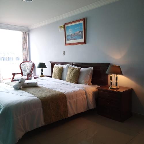 a bedroom with a large bed and a chair at HOTEL REALPICO VICTORIA in Duitama