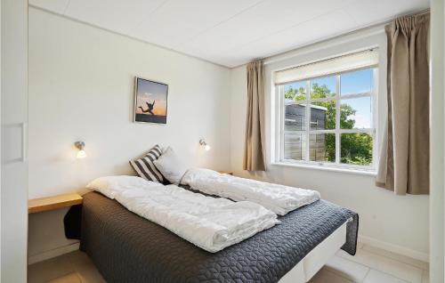 sypialnia z 2 łóżkami i oknem w obiekcie Amazing Home In Bagenkop With 3 Bedrooms And Wifi w mieście Bagenkop