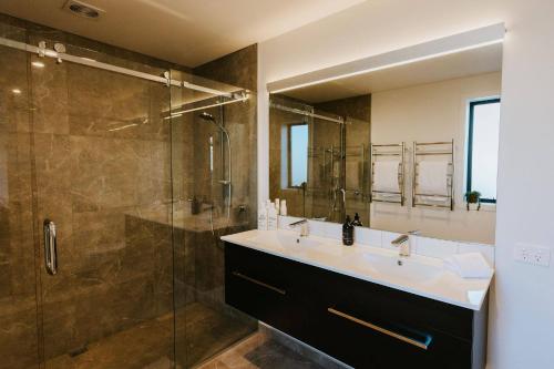 a bathroom with a sink and a shower at On The Rocks - Sleeps 8 - Family Friendly Holiday Home in Paraparaumu Beach