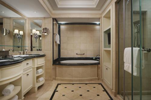 a bathroom with a tub and a sink and a shower at The Ritz-Carlton Beijing in Beijing