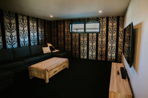 a living room with a couch and a coffee table at On The Rocks - Sleeps 8 - Family Friendly Holiday Home in Paraparaumu Beach