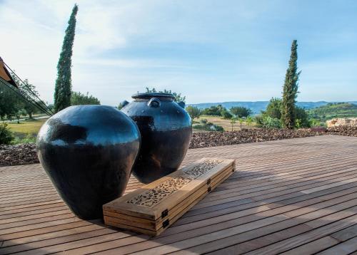 two large black vases sitting on a wooden deck at Masseria Della Volpe in Casale Modica