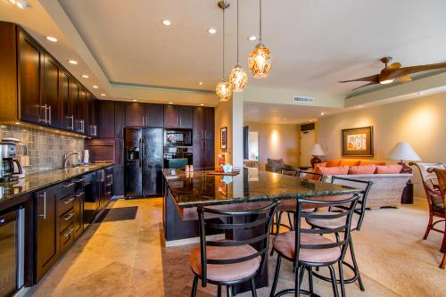 eine Küche und ein Wohnzimmer mit einer großen Insel mit Barhockern in der Unterkunft Kapalua Golf Villa 16V 2 in Kahana