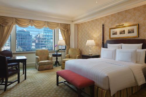 una camera d'albergo con letto, scrivania e sedie di The Ritz-Carlton Beijing a Pechino