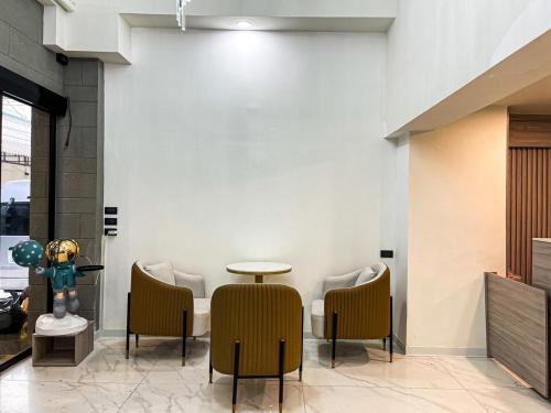 a room with chairs and a table and a wall at Nona Hotel, Bangkok in Makkasan