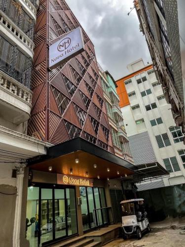 a golf cart parked in front of a building at Nona Hotel, Bangkok in Makkasan