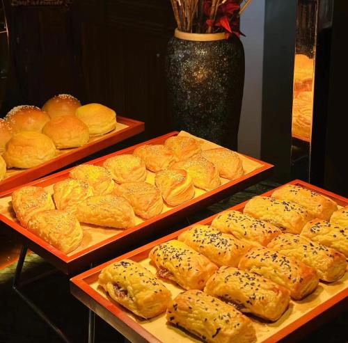 a display of breads and pastries on trays in a bakery at Sheraton Zhoushan Hotel in Zhoushan