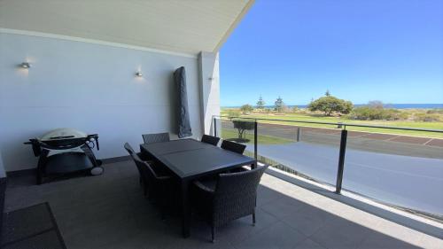a balcony with a table and chairs and a grill at The Pearl in Jurien Bay