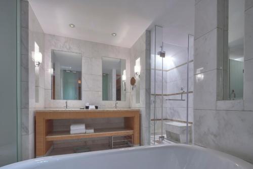 舟山的住宿－舟山喜來登綠城酒店，带浴缸、两个盥洗盆和镜子的浴室