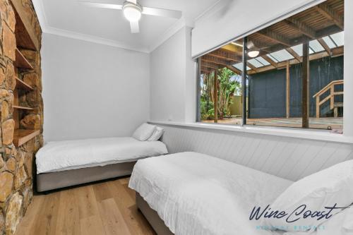 En eller flere senge i et værelse på Sun Daze by Wine Coast Holiday Rentals