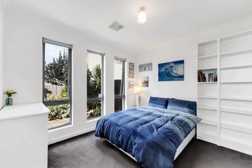 a bedroom with a bed and two windows at Stunning Sea Views in Excellent Location in Victor Harbor