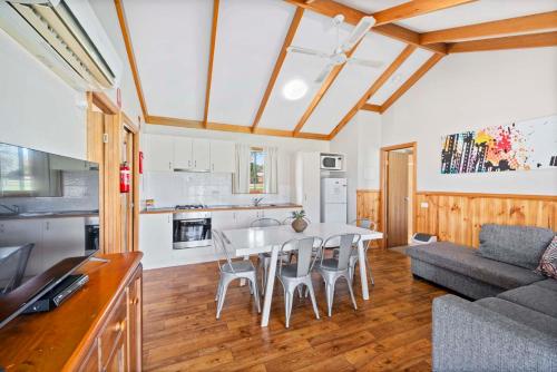 cocina y sala de estar con mesa y sillas en Lake Hume Holiday Park en Lake Hume