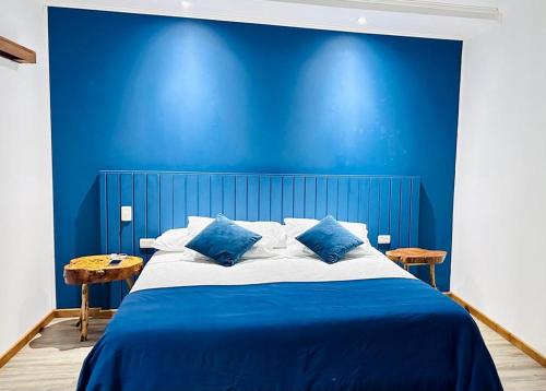 a blue bedroom with a large bed with blue walls at Apalta Lofts, disfruta frente a viñedos in Santa Cruz