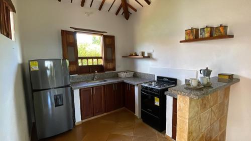 a kitchen with a stainless steel refrigerator and a sink at cabañas villa Angelica in Barichara