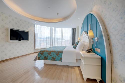 ein Hotelzimmer mit einem Bett und einem TV in der Unterkunft Morning Hotel, Chenzhou Railway Station in Chenzhou