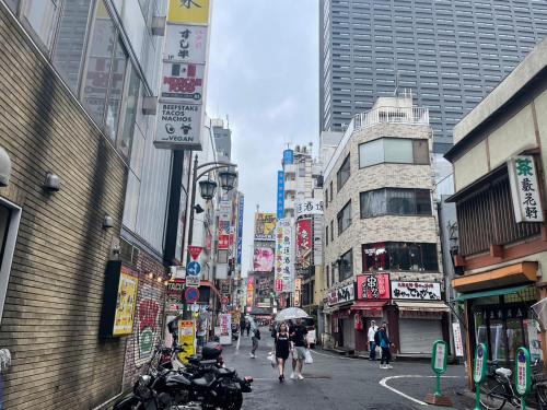 a busy city street with people walking down the street at 遊悠館 in Tokyo